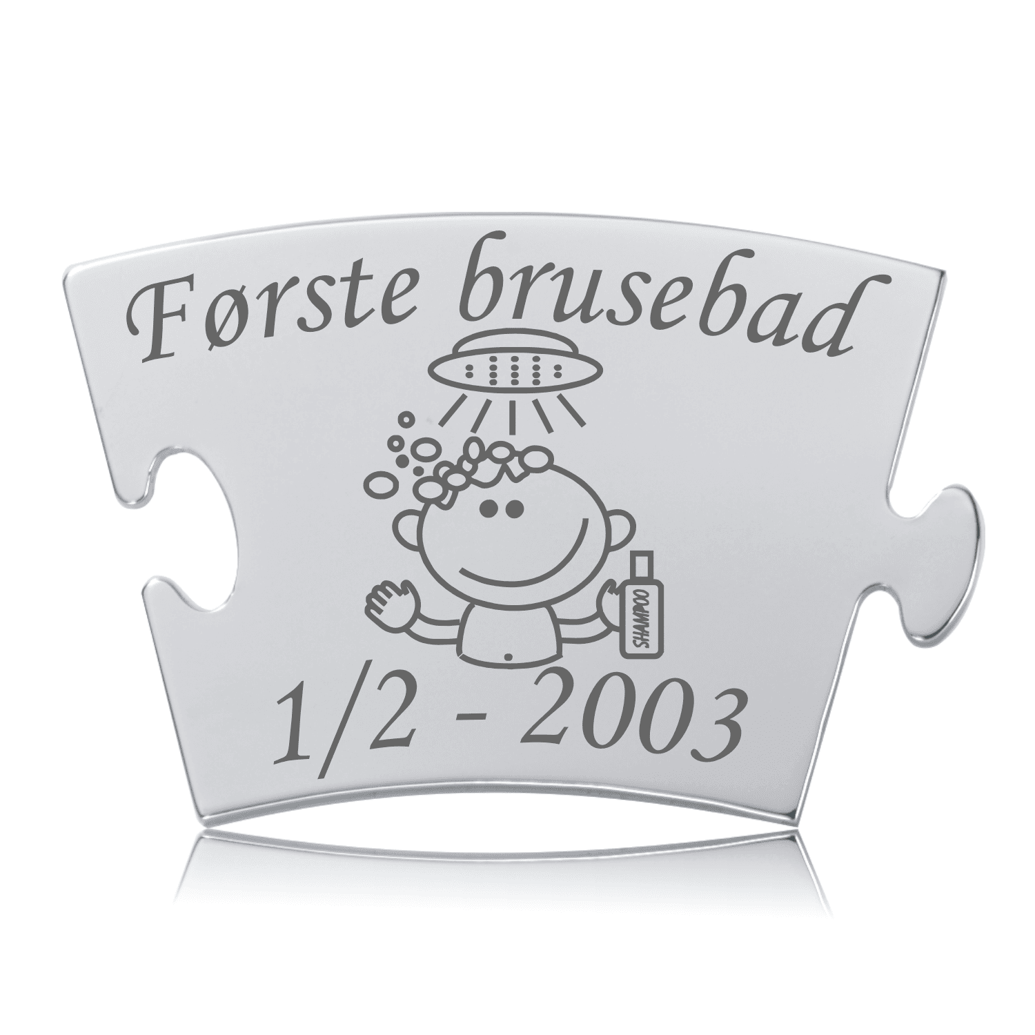 Memozz Classic brik i rustfrit stål med gravering af et barn under bruser, teksten "Første brusebad" og dato