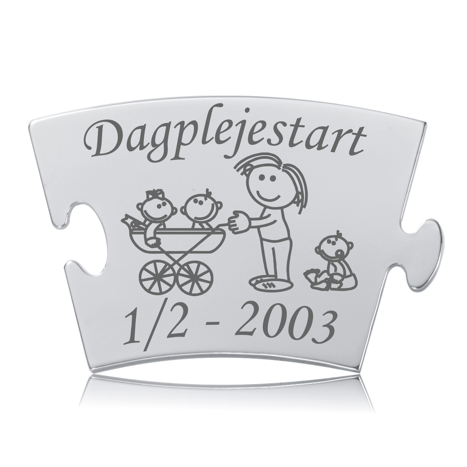 Dagplejestart Memozz Classic Brik Memozz Classic brik i rustfrit stål med gravering af "Dagplejestart", en venlig figur, der passer på to babyer i en barnevogn og en siddende baby.