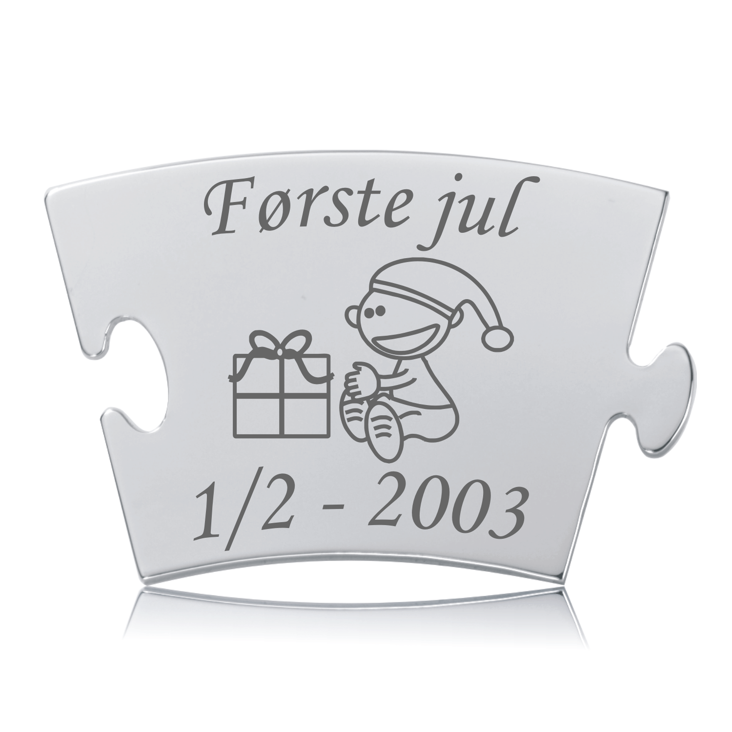 Memozz Classic mindebrik "Første jul - Model Gave" i rustfrit stål med gravering af smilende barn med nissehue, julegave og teksten "Første jul".