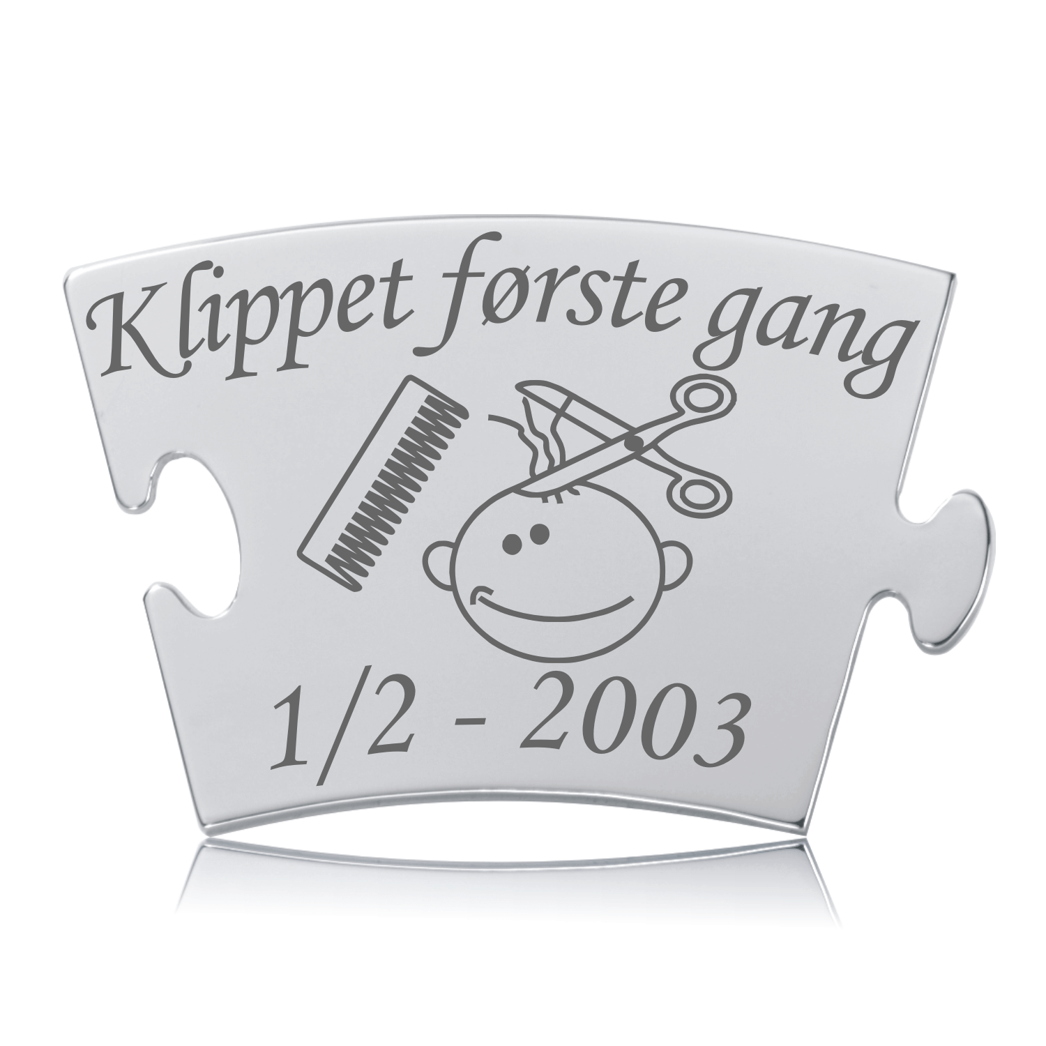 Blank Memozz brik i rustfrit stål til første klipning, med gravering af babyhoved, saks, kam og teksten "Klippet første gang"