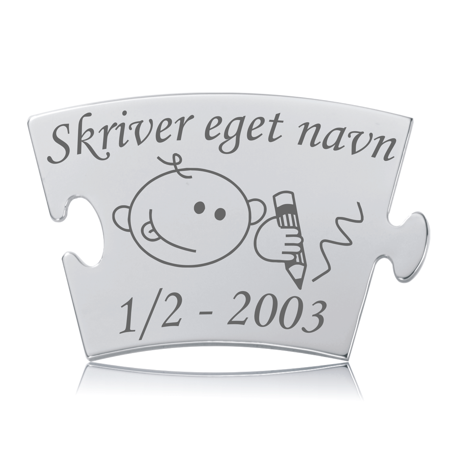 Skinnende Memozz Classic brik med gravering af et barn, der skriver. Teksten "Skriver eget navn" og en dato er tydelig.