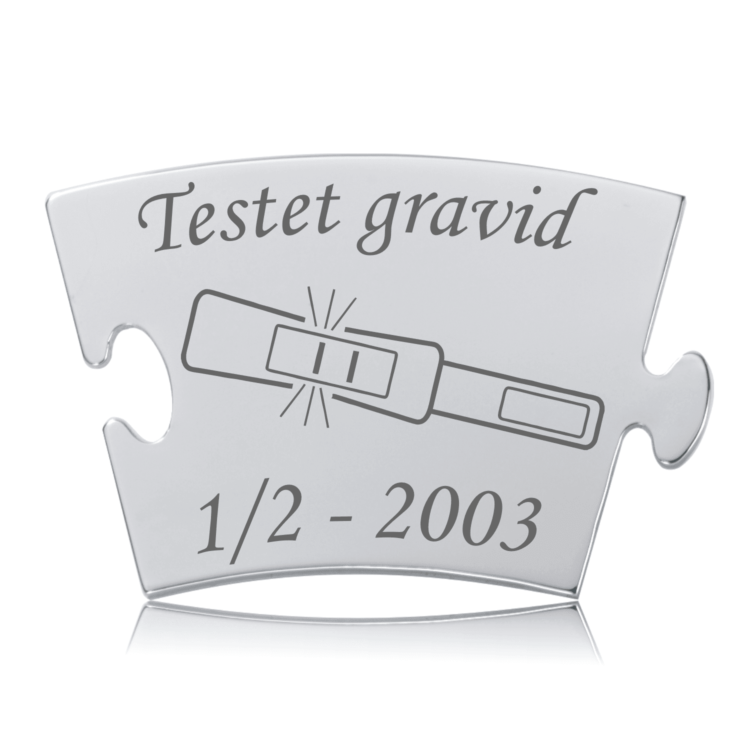 Blankpoleret Memozz Classic mindebrik med teksten "Testet gravid" og et ikon af en positiv graviditetstest graveret i mørkt stål.