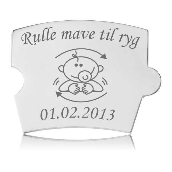 Memozz Spin brik i poleret stål med illustration af baby der ruller og teksten "Rulle mave til ryg"