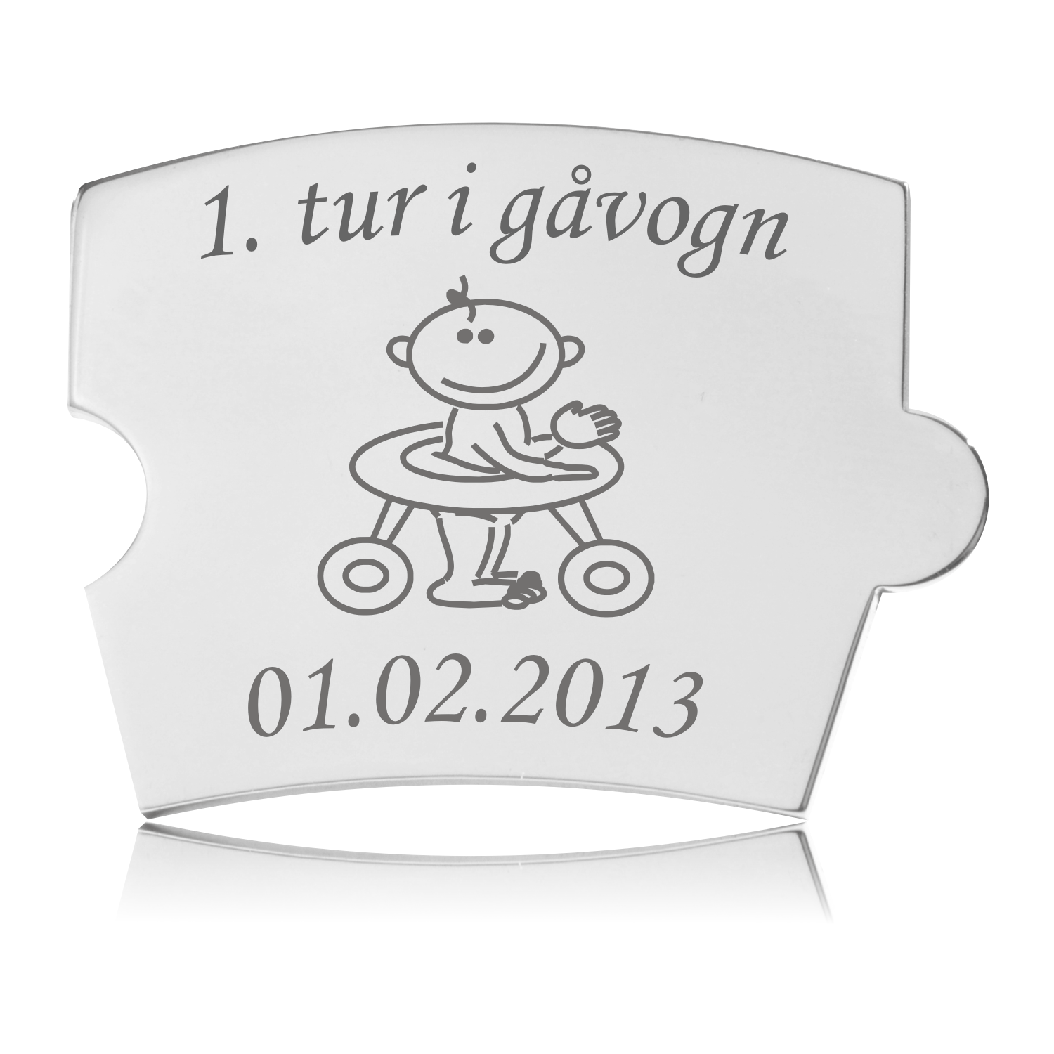 Memozz Spin brik i håndpoleret rustfrit stål med gravering af en baby i gåvogn og teksten "1. tur i gåvogn".