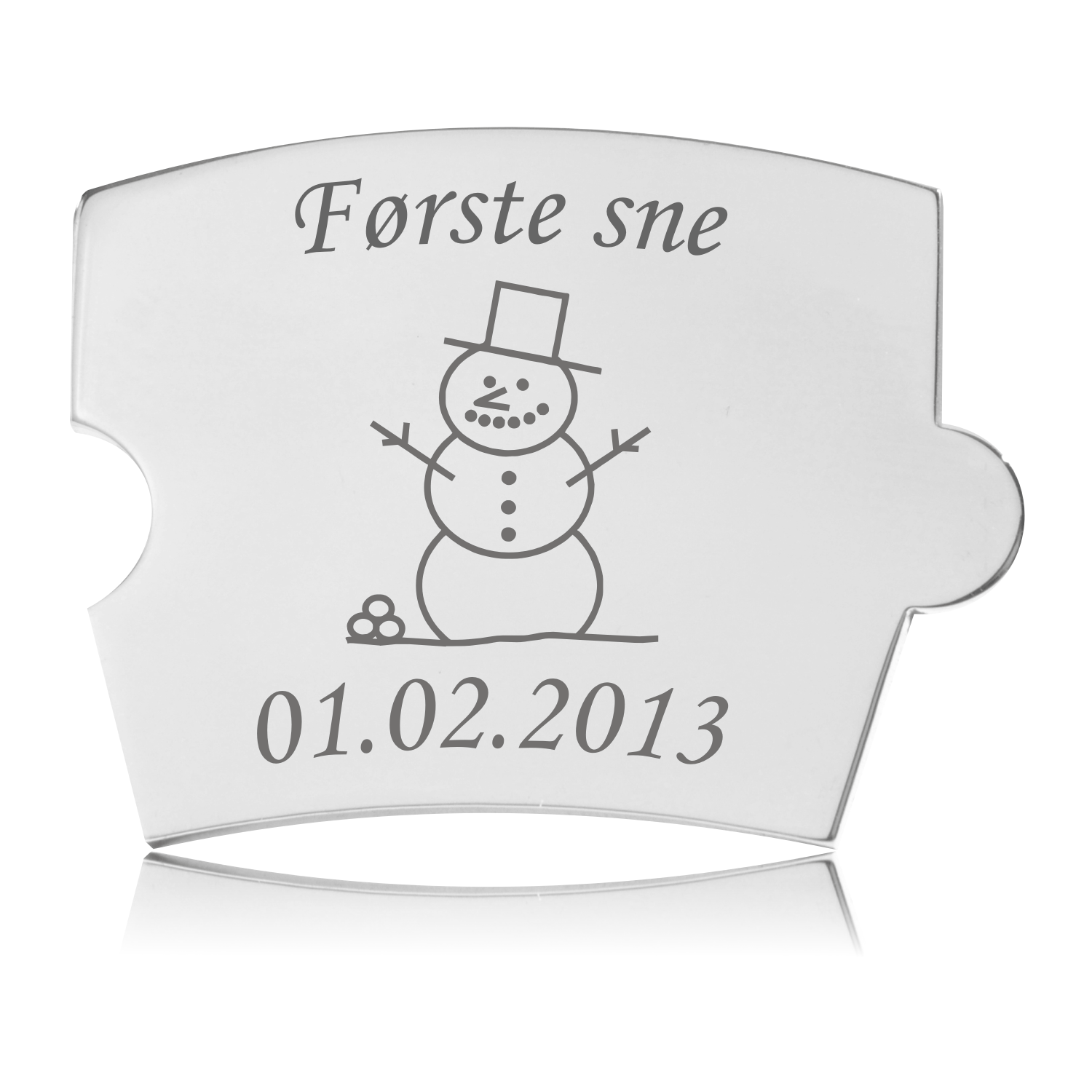 Memozz Spin brik i håndpoleret rustfrit stål med gravering af snemand og teksten "Første sne"