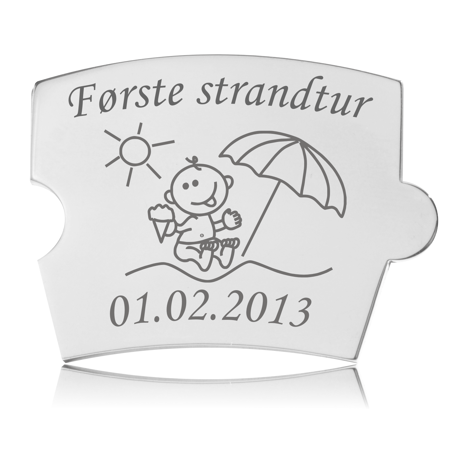 Memozz Spin brik "Første strandtur" i poleret rustfrit stål med lasergraveret motiv af baby på strand med is, sol og parasol.