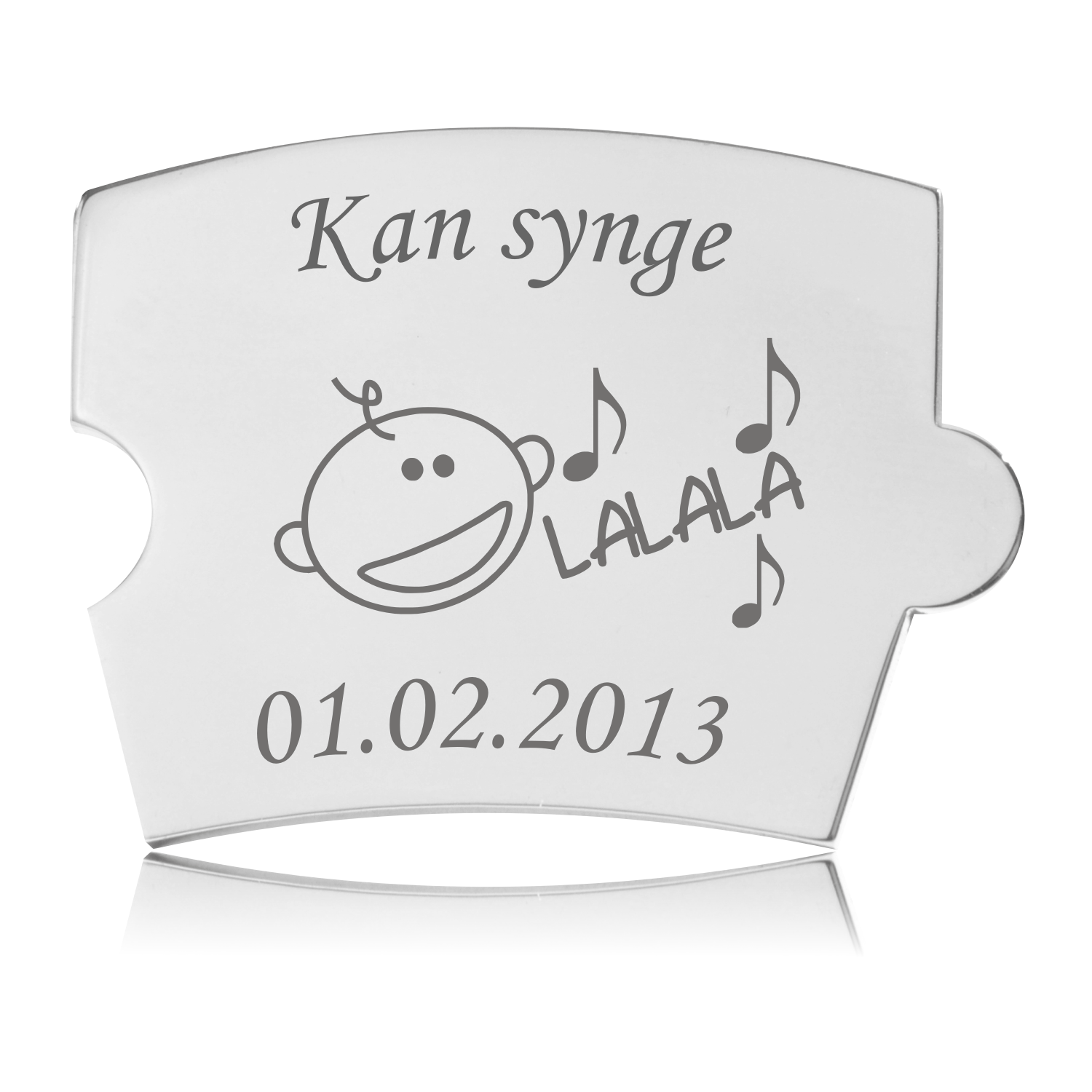 Memozz Spin brik i poleret rustfrit stål med gravering "Kan synge", et stiliseret barn fra siden og toner samt "LALALA".