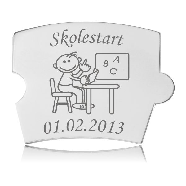 Memozz Spin brik med graveret motiv af dreng ved pult, der holder bog, symboliserer skolestart.