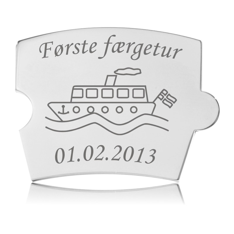 Memozz Spin mindebrik af håndpoleret rustfrit stål med gravering af en færge og teksten "Første færgetur".