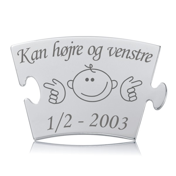 Memozz Classic Brik - Kan Højre og Venstre Gravering Memozz Classic brik i rustfrit stål med teksten "Kan højre og venstre" og et tegnet barneansigt der peger til siderne, graveret. Den glansfulde overflade reflekterer lyset og skaber en dybde i motivet.
