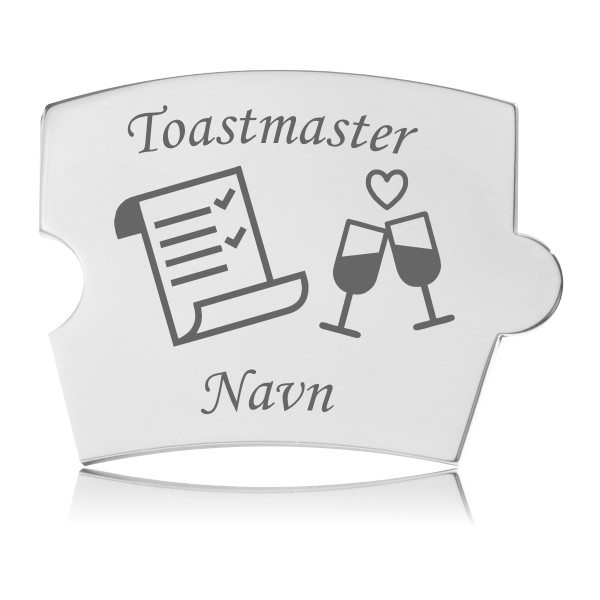 Memozz Spin brik i håndpoleret rustfrit stål med gravering af teksten "Toastmaster", en tjekliste, to champagneglas og teksten "Navn" for personliggørelse.