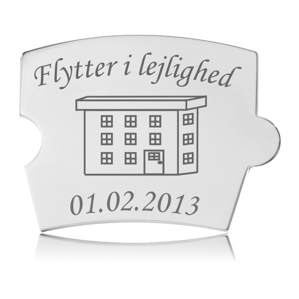 Memozz Spin brik i sølvfarvet stål med gravering af lejlighed og teksten "Flytter i lejlighed"
