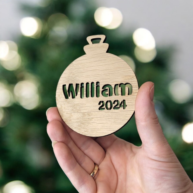 Personlig Julekugle i Egefiner - Med Udskåret Navn og Årstal Personligt designet julekugle i egefiner med udskåret navn og årstal – perfekt til juletræet eller som gave.