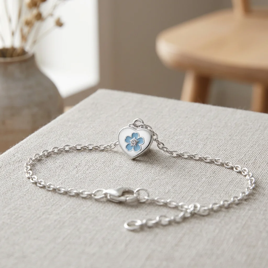 Armbånd med hjerte og blå blomst - Skandinavisk stil Sølv armbånd med hjerte og blå blomst på et træbord i et lyst skandinavisk hjem